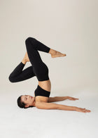 Flowmango Inner Flow Leggings in black during a reclined Pilates pose
