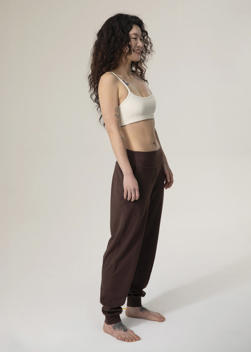 Side view of model standing in brown Flowmango jogger pants