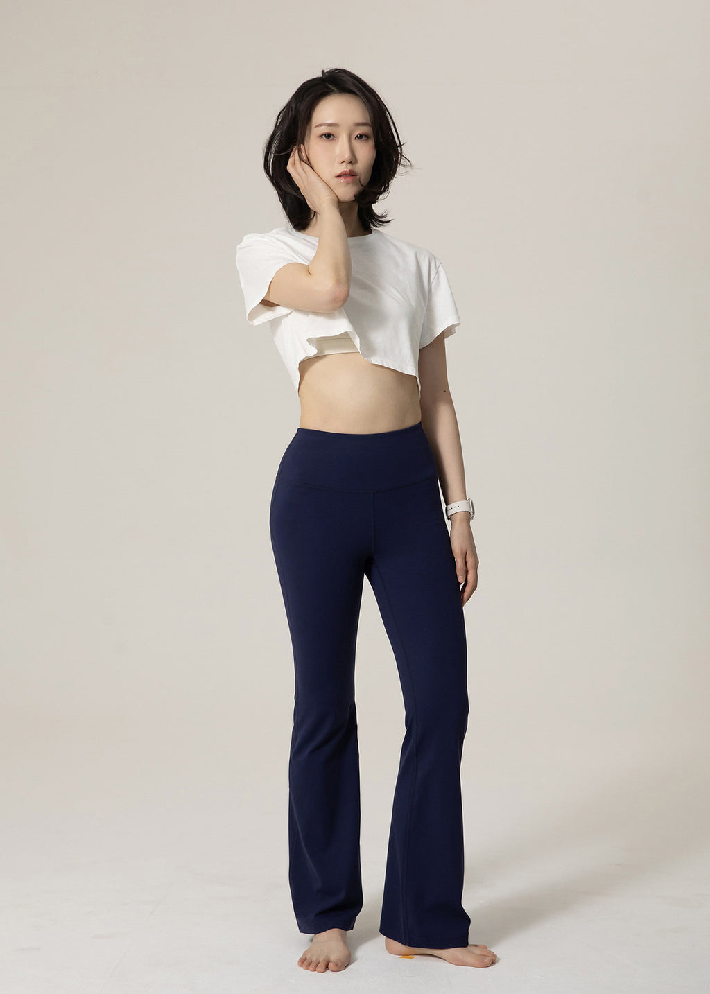 Three-quarter front view of navy Deep Flow Flared Leggings on a standing model