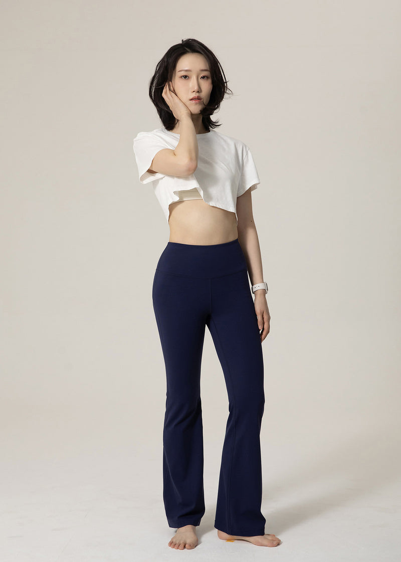 Three-quarter front view of navy Deep Flow Flared Leggings on a standing model