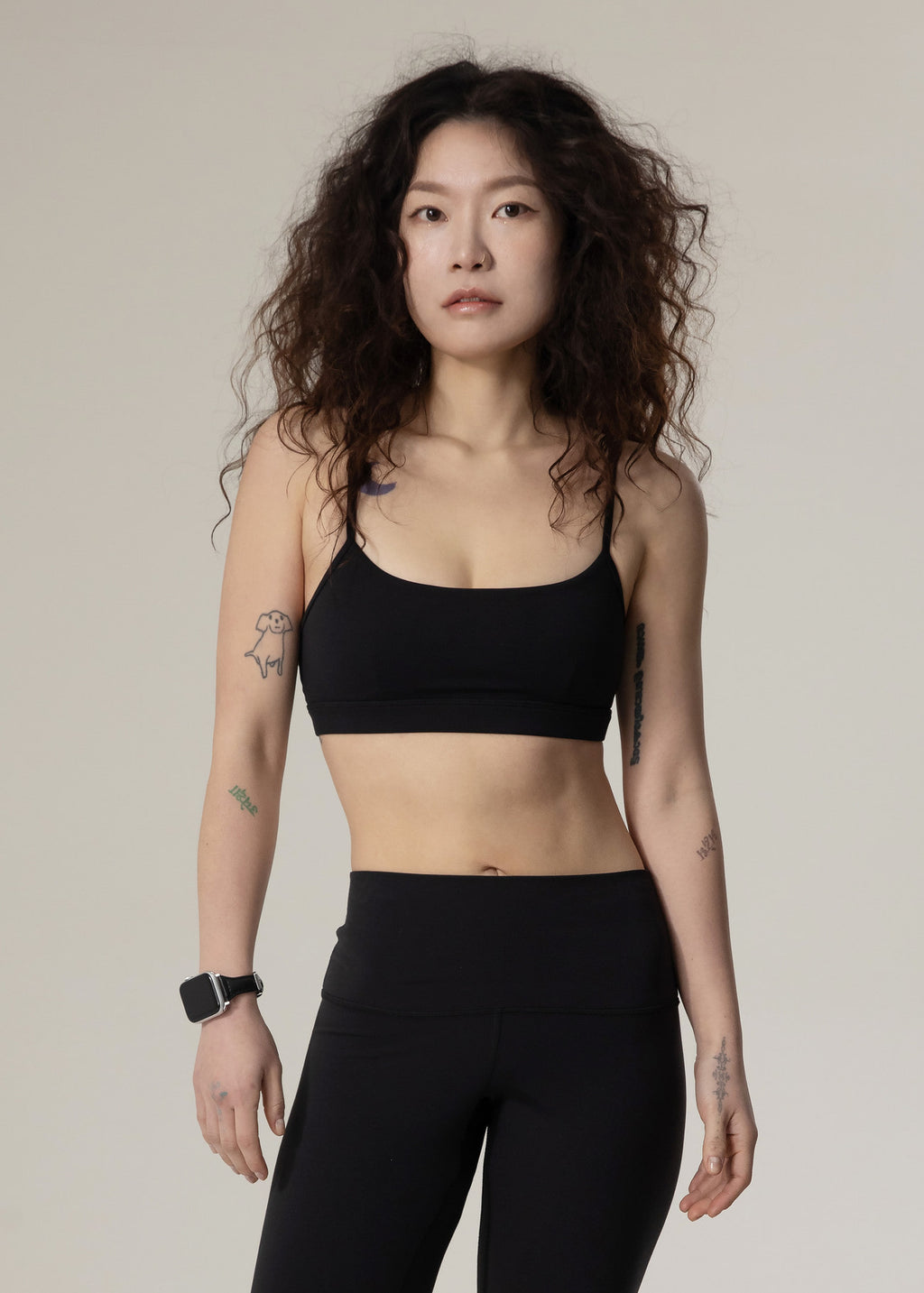 Front view of model wearing black Flowmango Inner Flow bra with black leggings